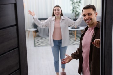 Photo of Lovely couple welcoming guests to their apartment