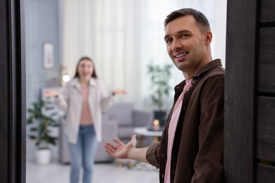 Lovely couple welcoming guests to their apartment, selective focus