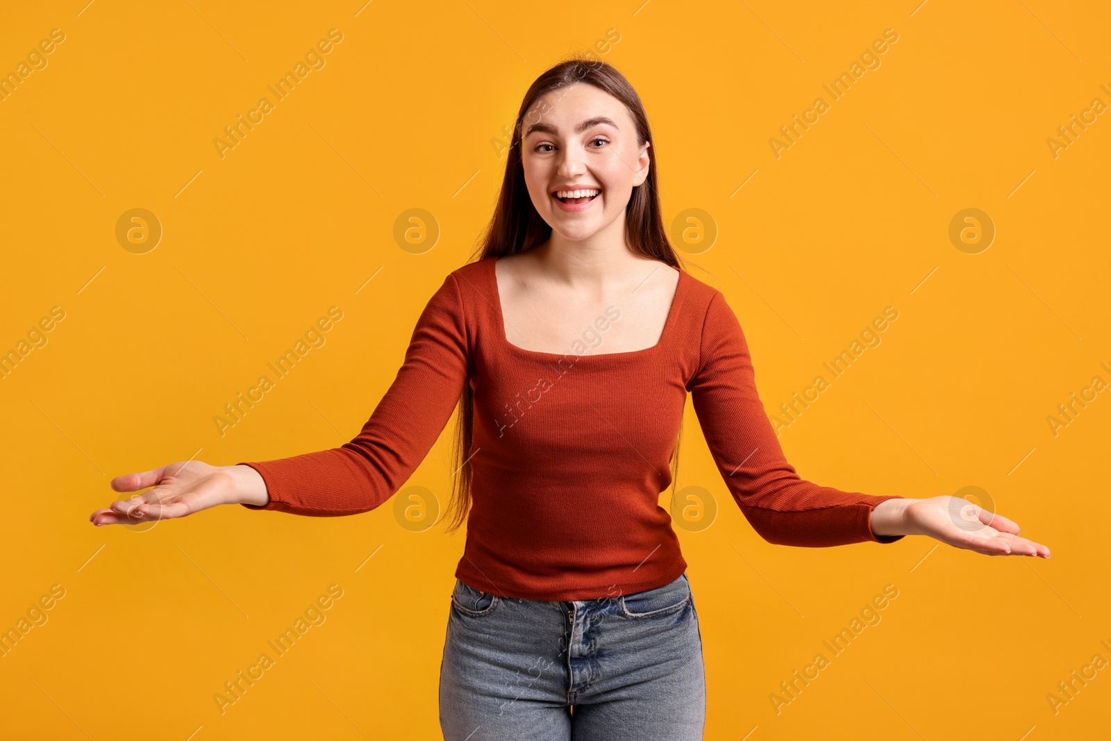 Photo of Happy woman welcoming guests on orange background