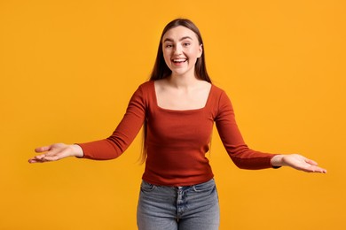 Photo of Happy woman welcoming guests on orange background