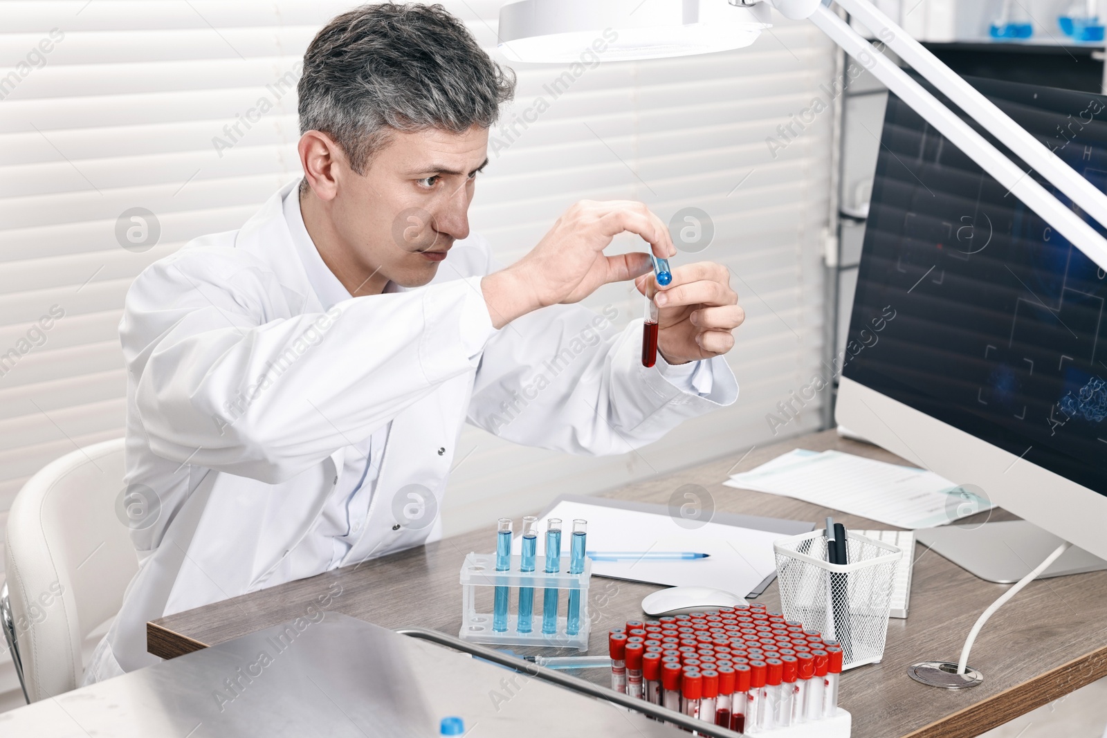 Photo of Scientist with test tubes working in laboratory