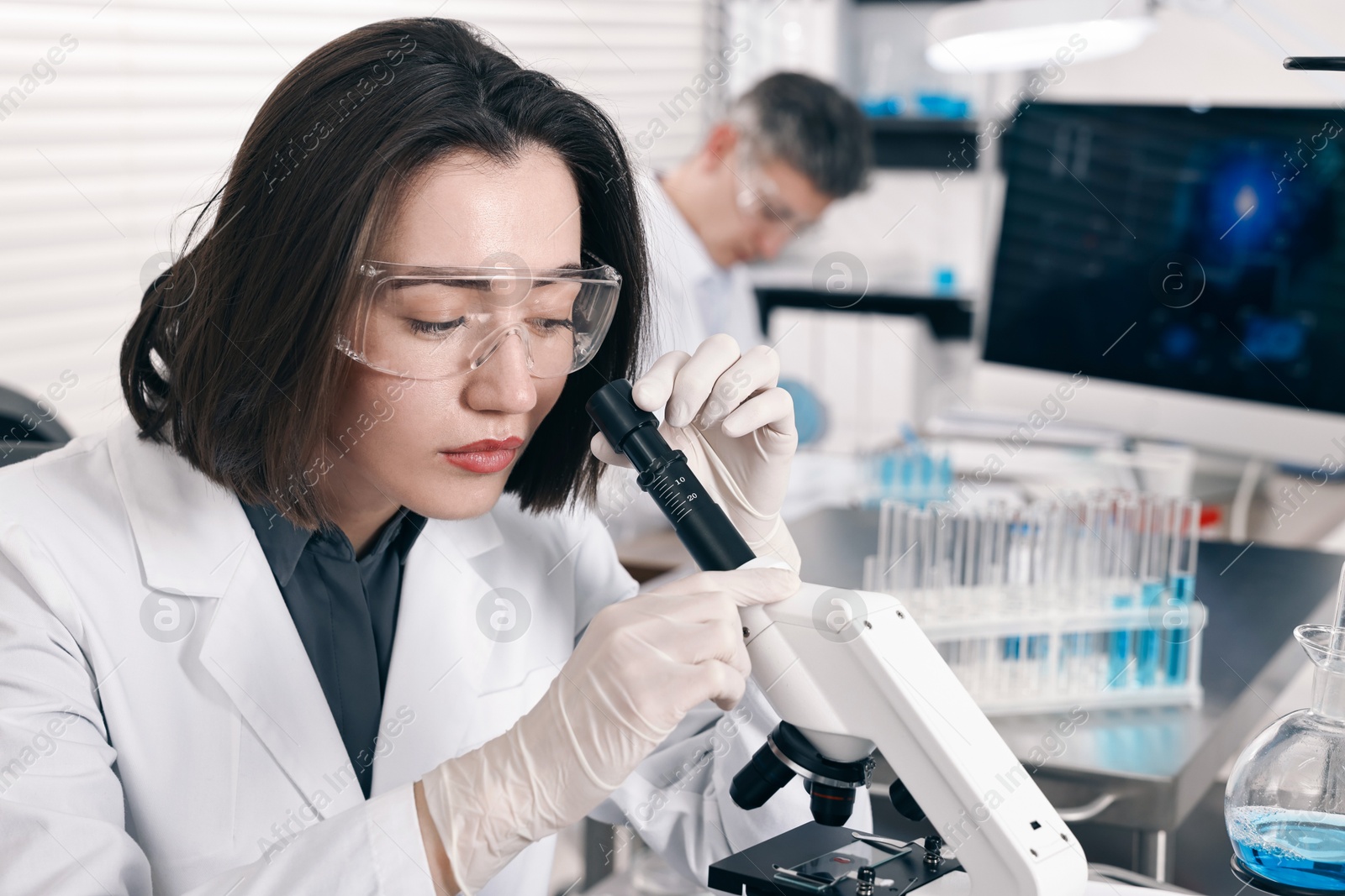 Photo of Scientist working with modern microscope in laboratory