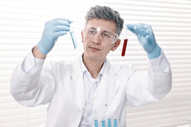 Photo of Scientist with test tubes working in laboratory