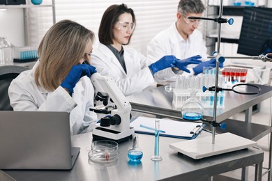 Photo of Scientists working with samples at table in laboratory