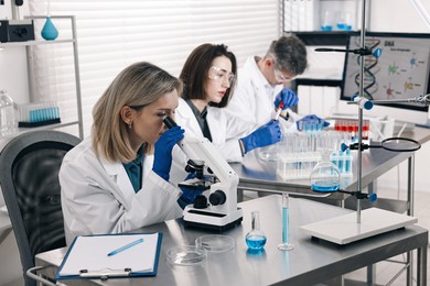 Scientists working with samples at table in laboratory