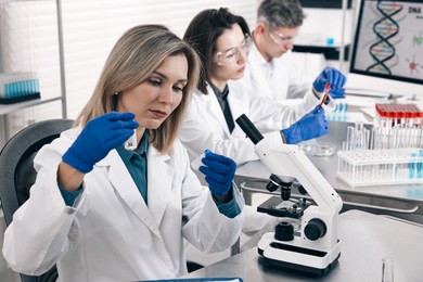 Photo of Scientists working with samples at table in laboratory