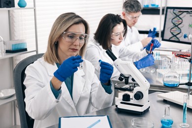 Photo of Scientists working with samples at table in laboratory