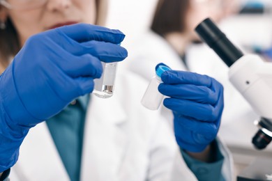 Photo of Scientist with vials working in laboratory, closeup