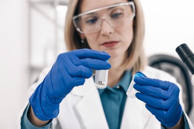 Photo of Scientist with vials working in laboratory, selective focus