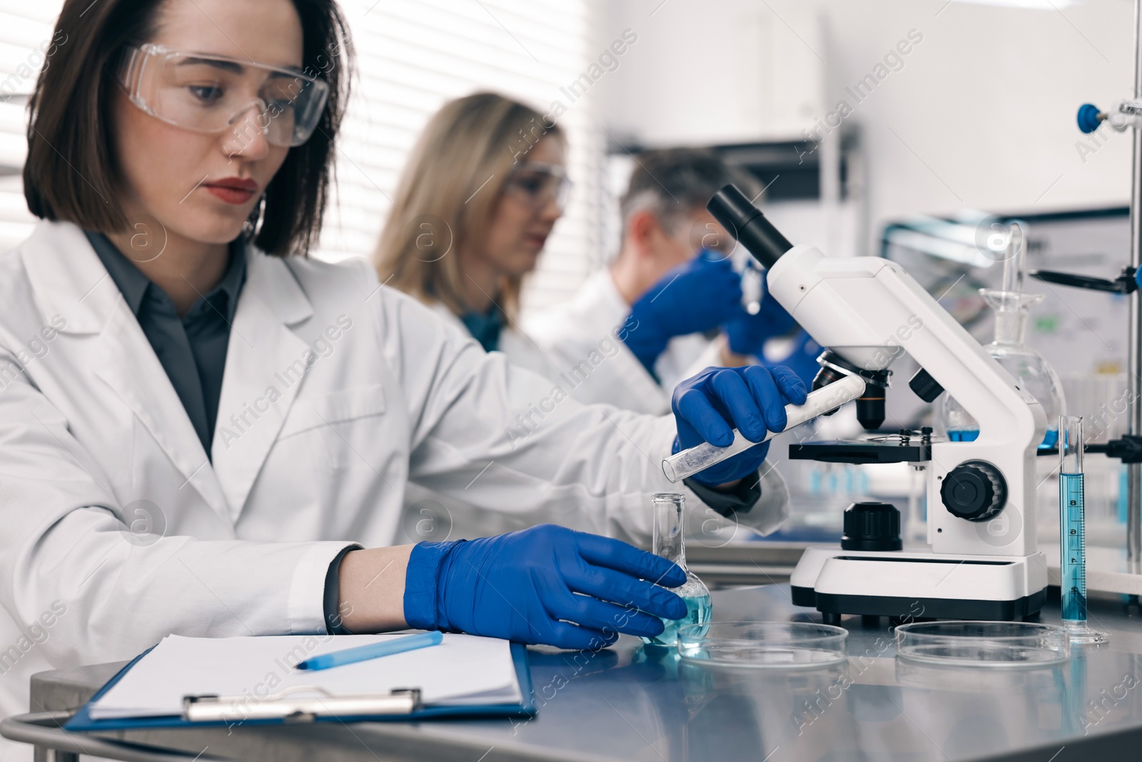 Photo of Scientist with test tube and flask working in laboratory