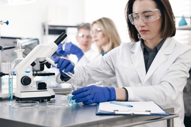 Photo of Scientist with test tube and flask working in laboratory