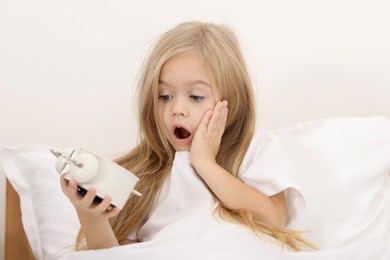 Photo of Overslept girl with alarm clock in bed at home