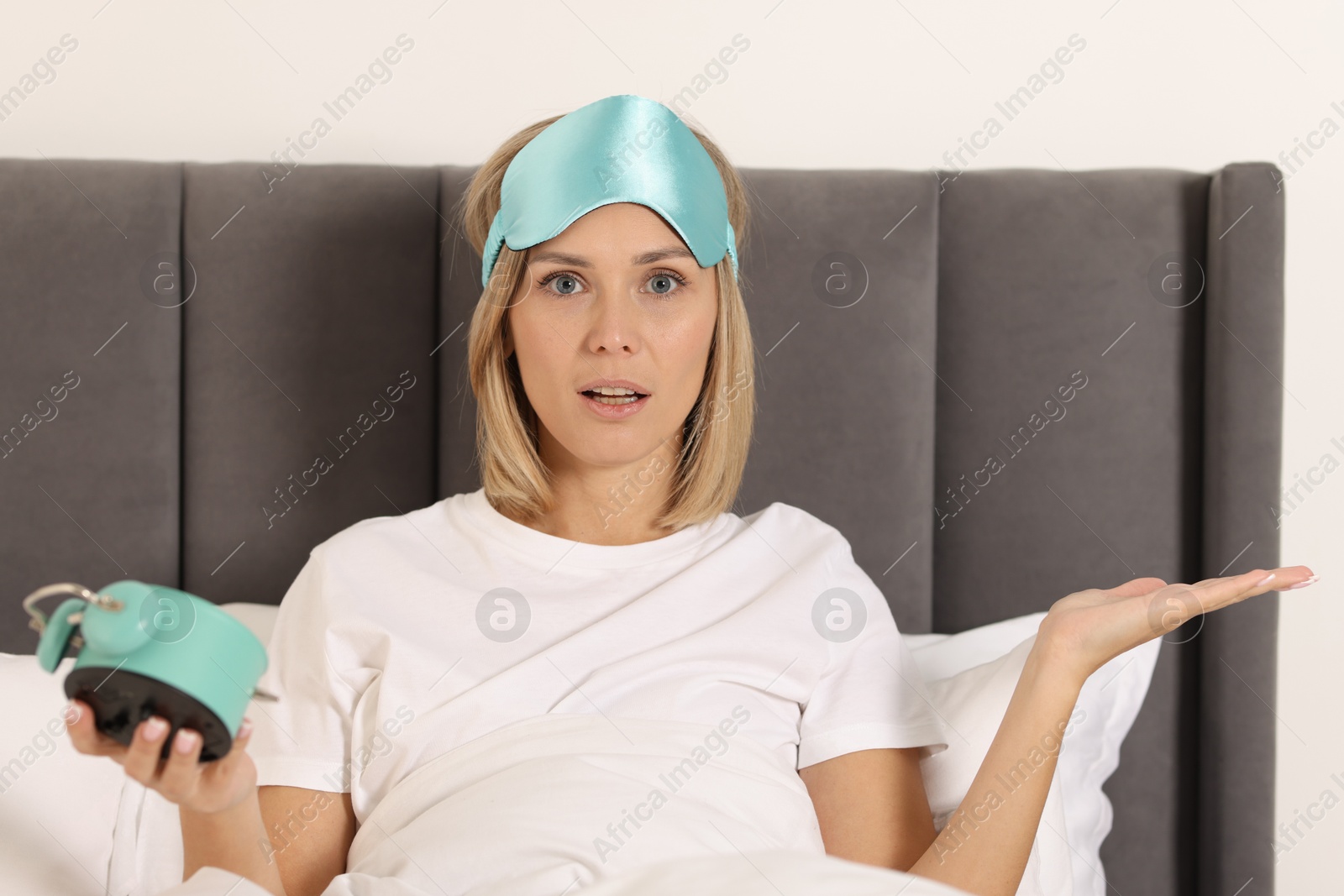 Photo of Overslept woman with alarm clock in bed at home