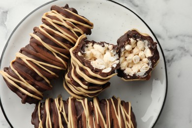 Photo of Delicious chocolate puffed rice bars on white marble table, top view