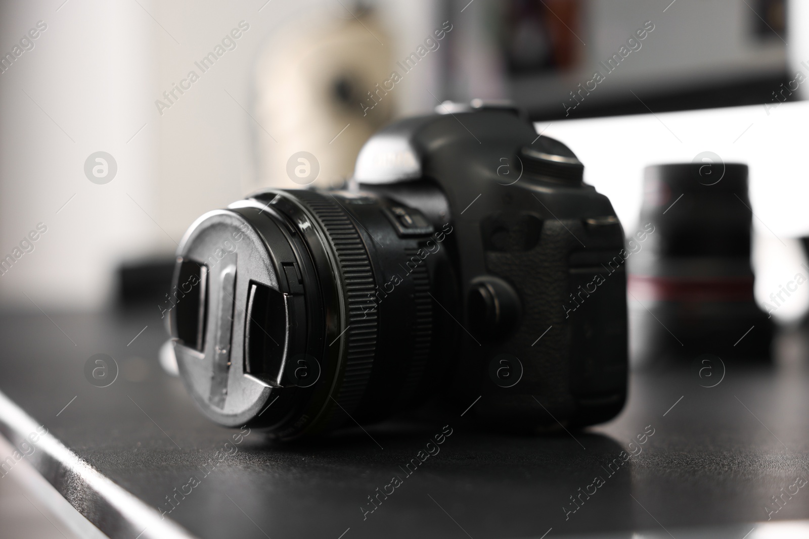 Photo of Professional camera on black desk indoors, closeup