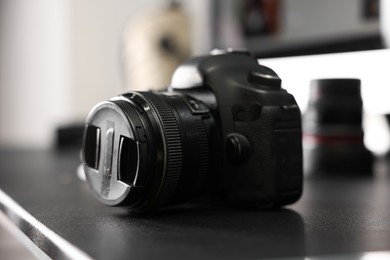 Photo of Professional camera on black desk indoors, closeup