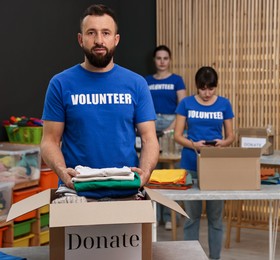 Photo of Volunteers packing donation goods at tables indoors