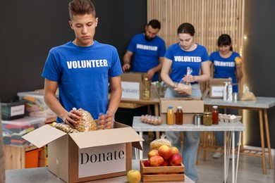 Photo of Volunteers packing food donations at tables indoors