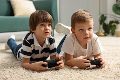 Photo of Cute brothers playing video game on floor at home