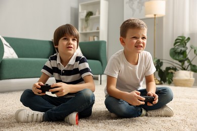 Photo of Cute brothers playing video game on floor at home