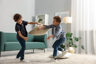 Photo of Brothers having fun pillow fight at home