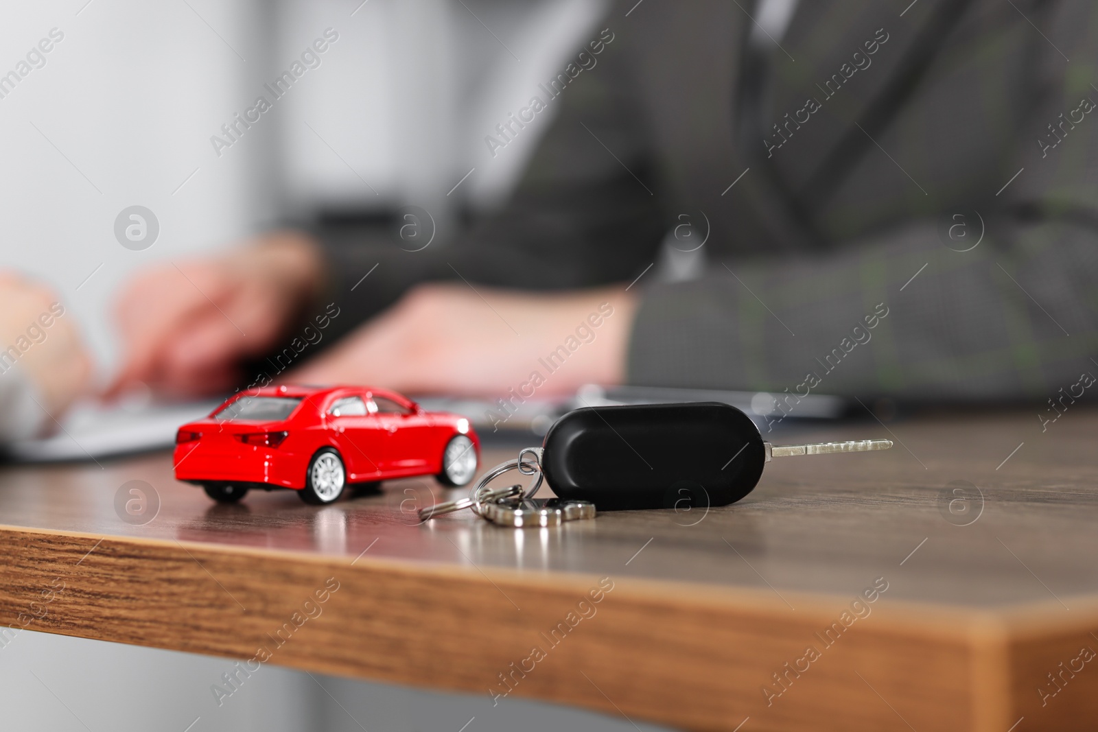 Photo of Manager and client signing car purchase agreement at wooden table, selective focus. Buying auto