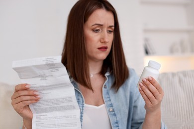 Photo of Woman with bottle of pills and instruction indoors