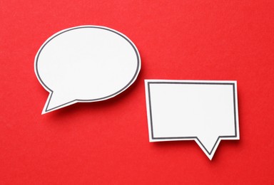 Photo of Blank speech bubbles on red background, top view. Space for text