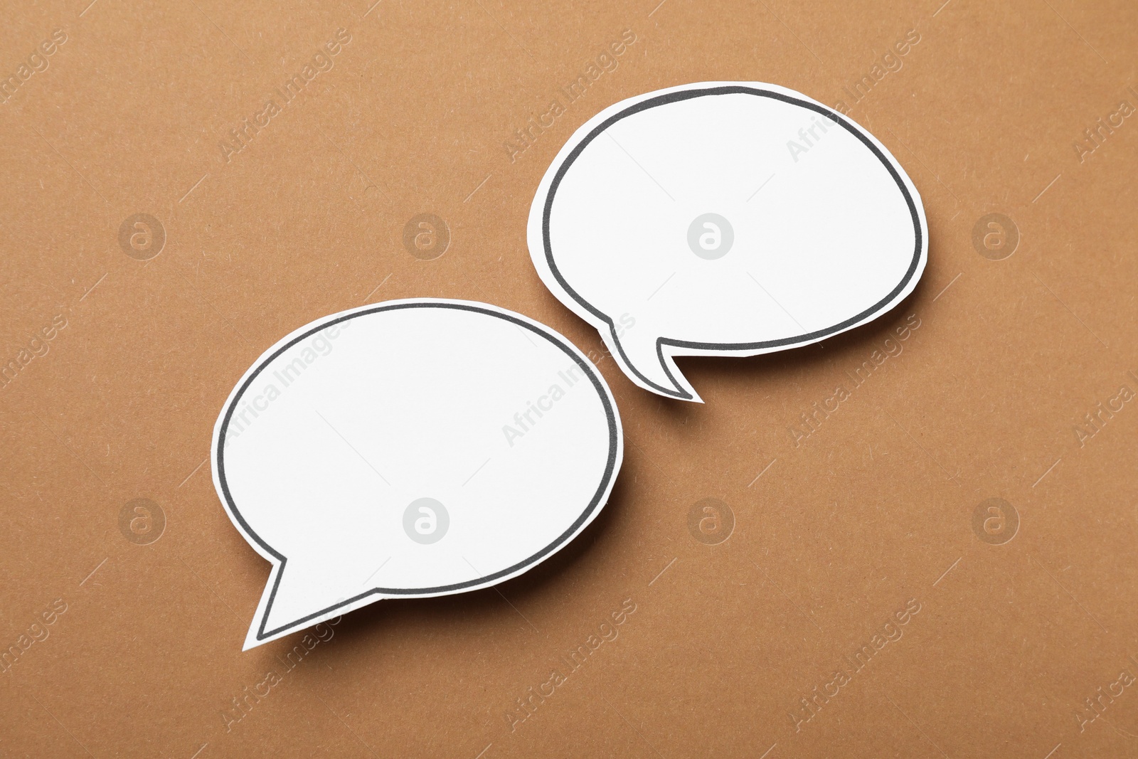 Photo of Blank speech bubbles on brown background. Space for text