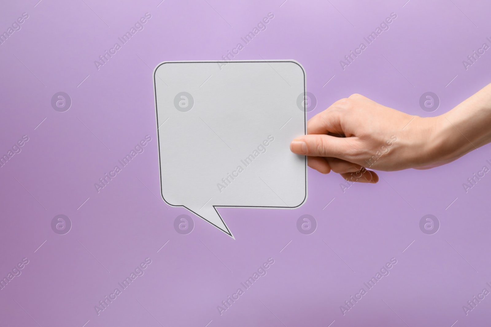 Photo of Woman holding blank speech bubble on lilac background, closeup. Space for text