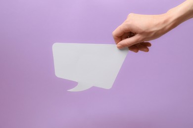 Photo of Woman holding blank speech bubble on lilac background, closeup. Space for text