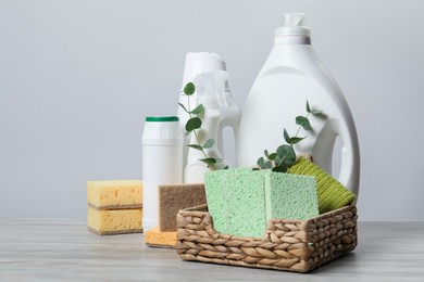 Photo of Eco-friendly cleaning products, supplies and eucalyptus branches on wooden table, space for text