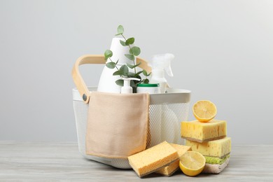 Photo of Eco-friendly cleaning products, supplies and eucalyptus branches on wooden table