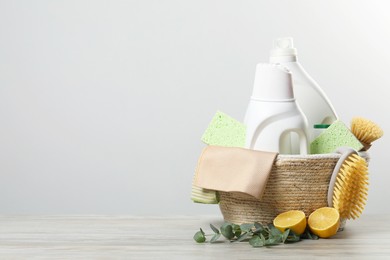 Photo of Eco-friendly cleaning products, supplies and eucalyptus branches on wooden table, space for text