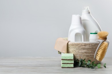 Photo of Eco-friendly cleaning products, supplies and eucalyptus branches on wooden table, space for text