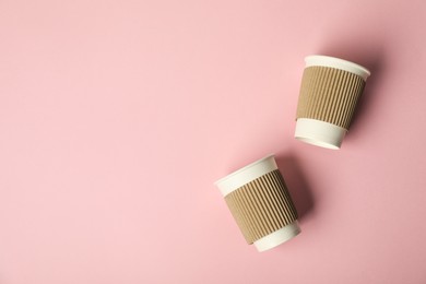 Photo of Paper cups on pink background, flat lay. Mockup for design