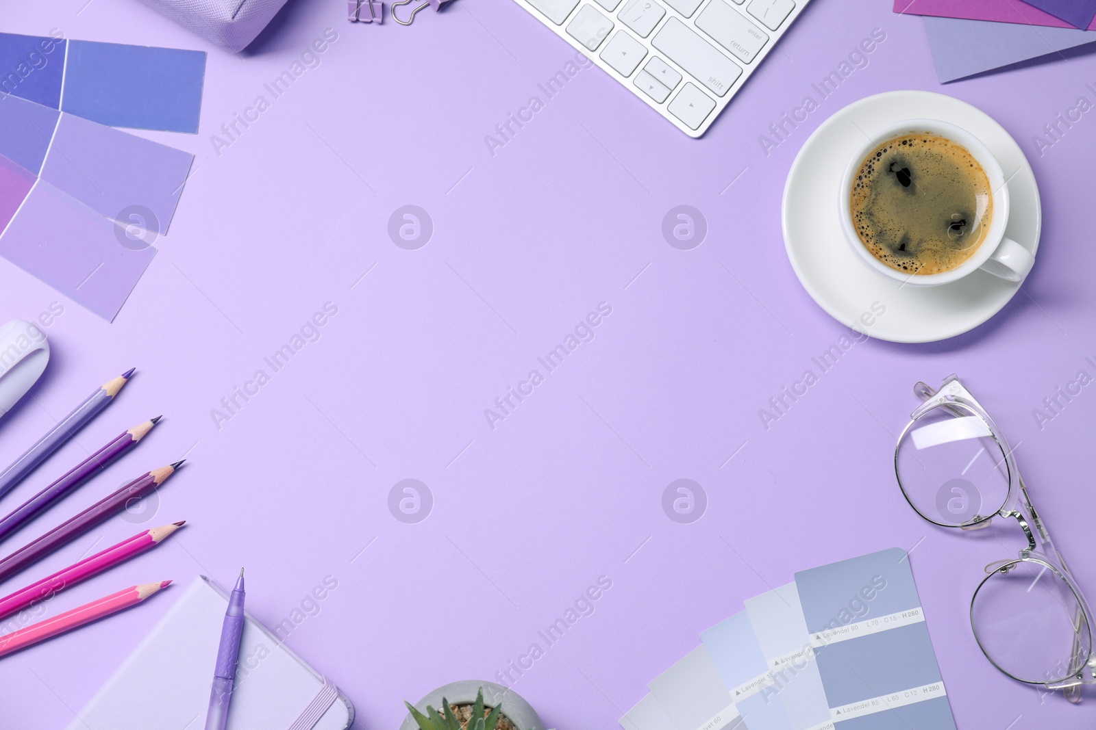 Photo of Designer's workplace with keyboard, stationery and cup of coffee on lilac background, flat lay. Space for text