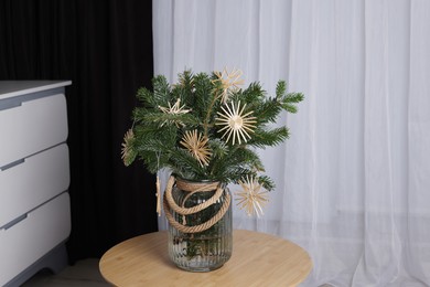 Photo of Beautiful Christmas composition of decorated fir tree branches on table indoors