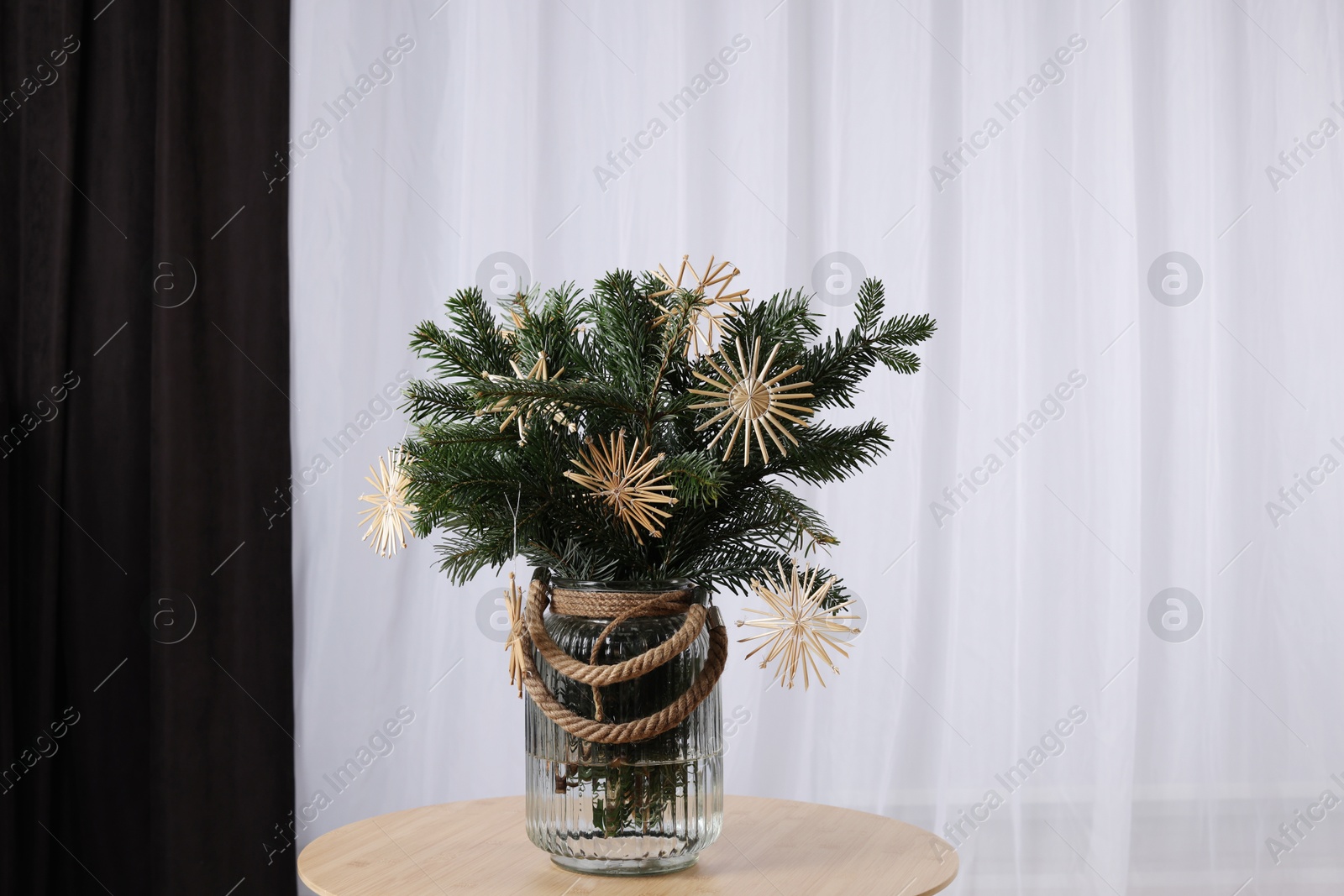 Photo of Beautiful Christmas composition of decorated fir tree branches on table indoors