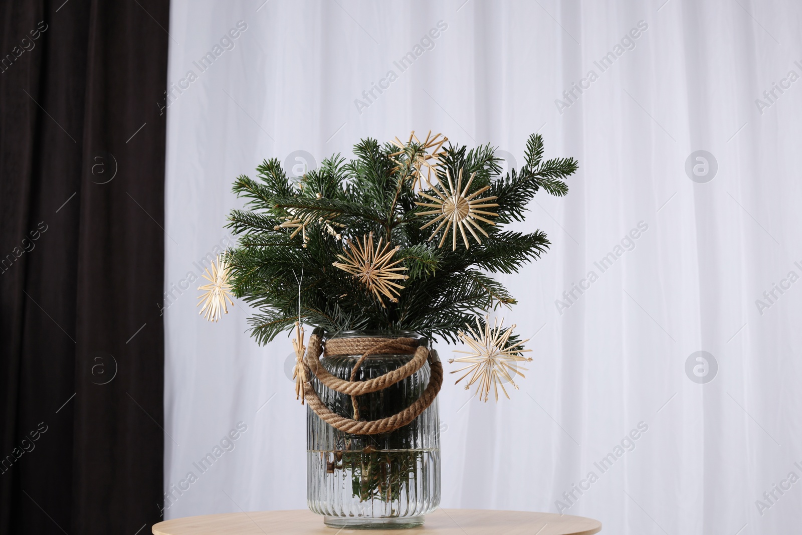 Photo of Beautiful Christmas composition of decorated fir tree branches on table indoors