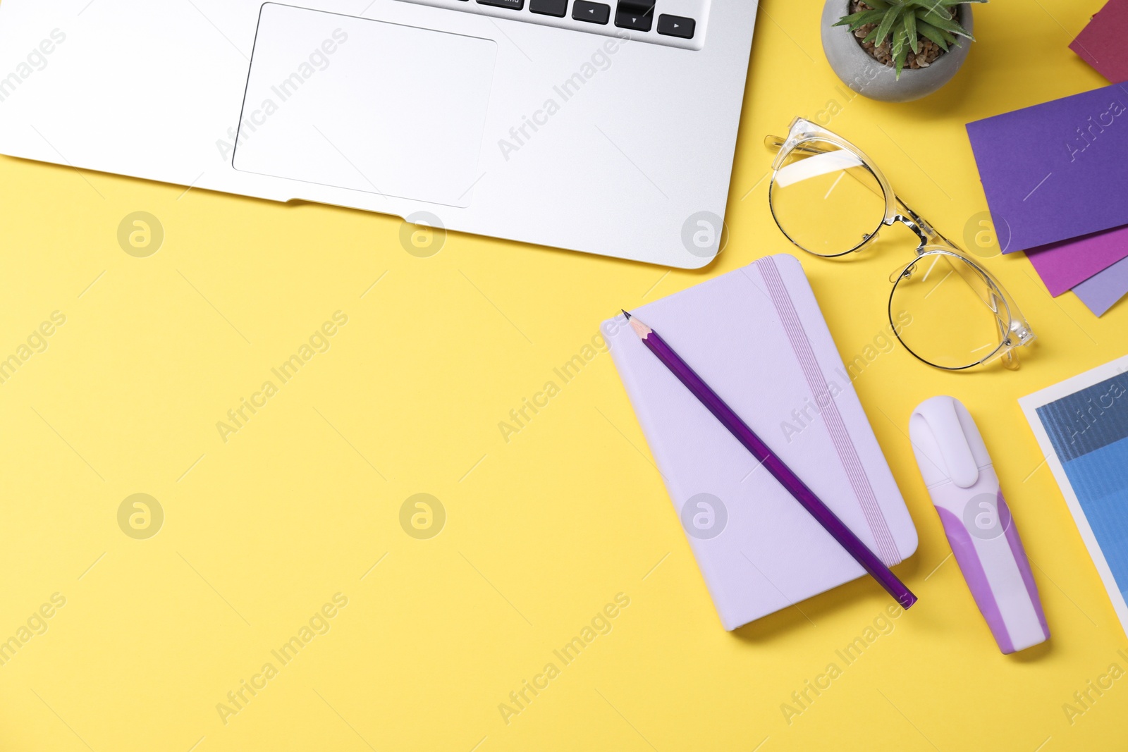 Photo of Designer's workplace. Flat lay composition with stationery and laptop on yellow background, space for text