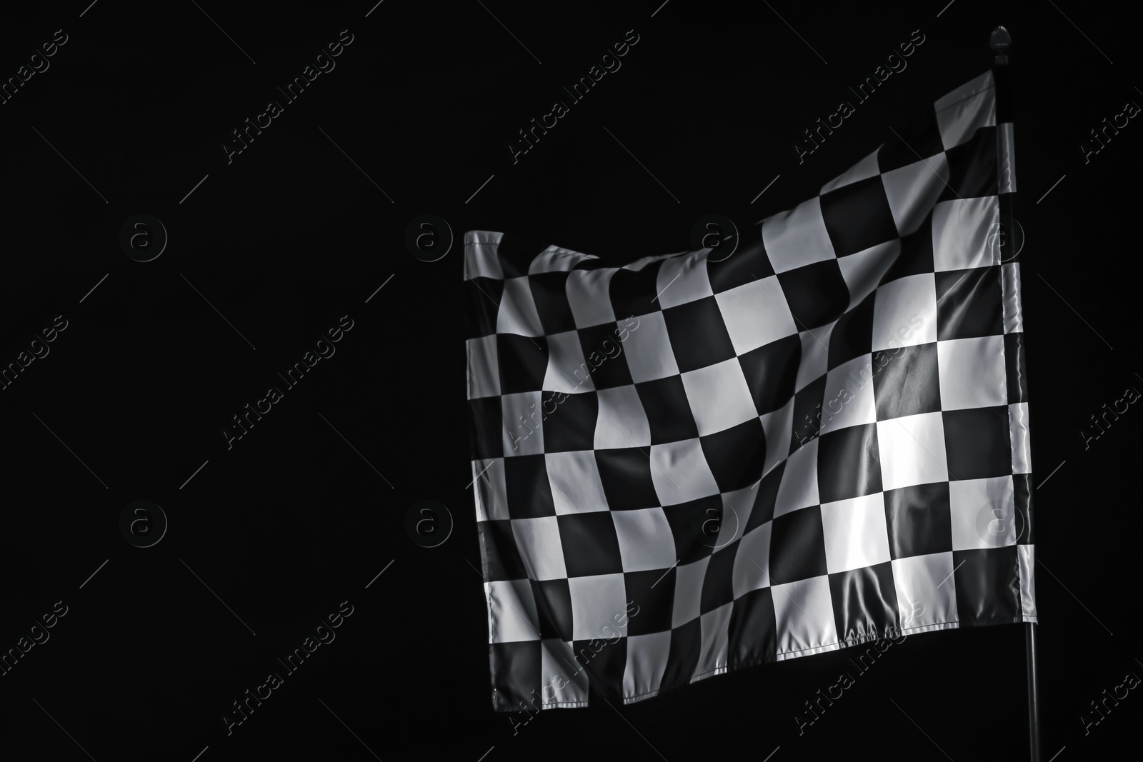 Photo of One racing checkered flag on black background, space for text