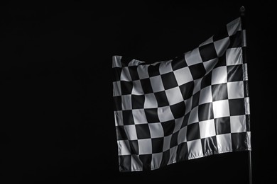 Photo of One racing checkered flag on black background, space for text