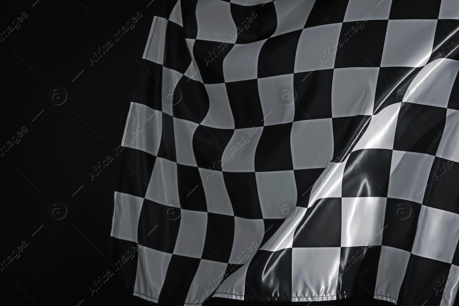 Photo of One racing checkered flag on black background, closeup