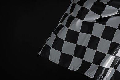 Photo of One racing checkered flag on black background, space for text