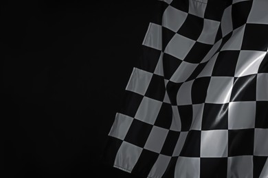 Photo of One racing checkered flag on black background, space for text