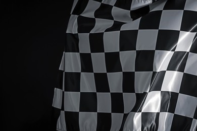 Photo of One racing checkered flag on black background, space for text