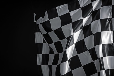 Photo of One racing checkered flag on black background, space for text