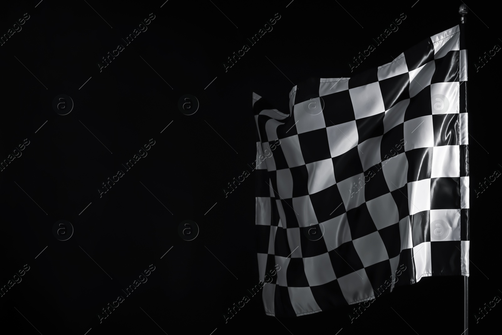 Photo of One racing checkered flag on black background, space for text