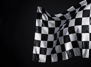 Photo of One racing checkered flag on black background, space for text